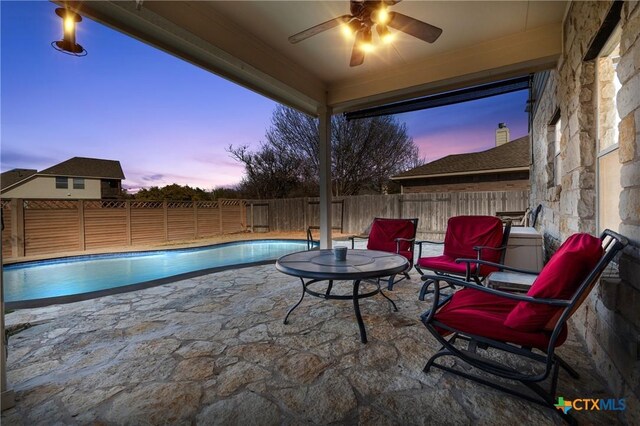 view of swimming pool with a ceiling fan, a patio area, a fenced in pool, and a fenced backyard