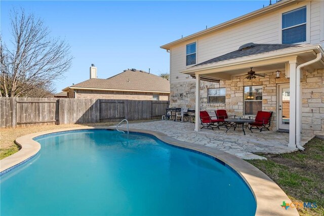 view of swimming pool featuring a fenced in pool, a fenced backyard, a ceiling fan, and a patio area