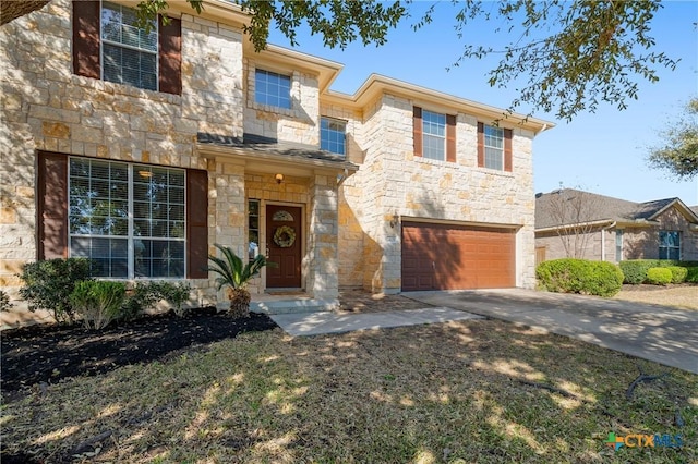 traditional home featuring stone siding, an attached garage, and concrete driveway