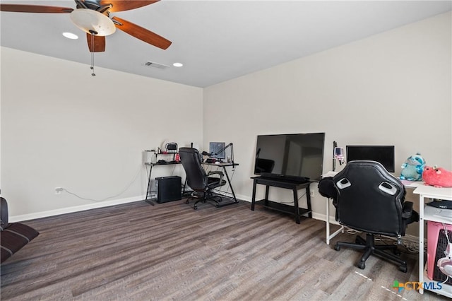 office space featuring visible vents, baseboards, light wood-style floors, and a ceiling fan