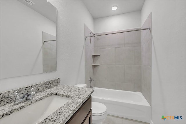 full bathroom with tiled shower / bath, vanity, and toilet