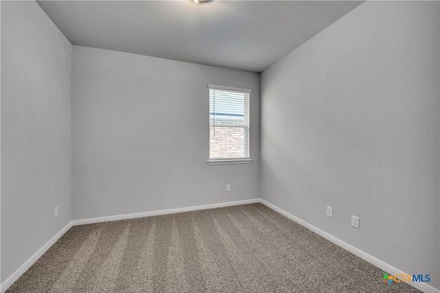 carpeted spare room featuring a textured ceiling