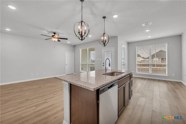 kitchen featuring sink, light wood-type flooring, dishwasher, an island with sink, and pendant lighting