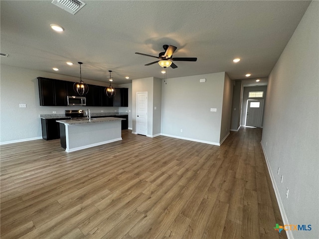 kitchen featuring sink, appliances with stainless steel finishes, ceiling fan, a kitchen island with sink, and dark hardwood / wood-style flooring