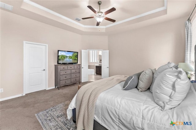 carpeted bedroom featuring ornamental molding and a tray ceiling