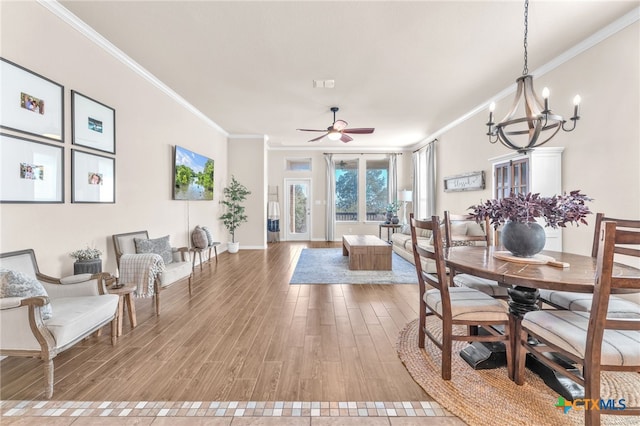 dining room featuring hardwood / wood-style flooring, crown molding, and ceiling fan with notable chandelier