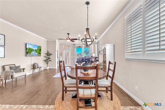 dining area with crown molding, ceiling fan with notable chandelier, and hardwood / wood-style floors