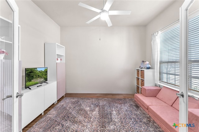 sitting room featuring ceiling fan and french doors