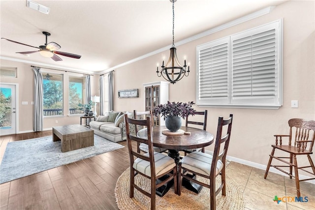 dining space featuring crown molding, ceiling fan with notable chandelier, and hardwood / wood-style flooring