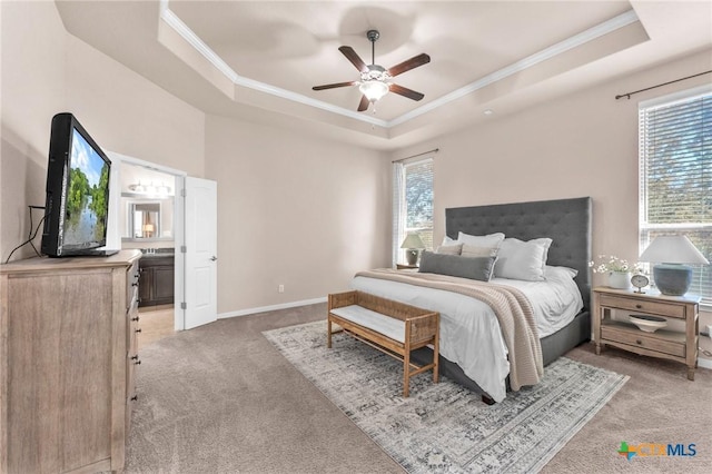 carpeted bedroom featuring crown molding, ceiling fan, connected bathroom, and a tray ceiling