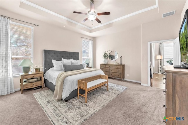 carpeted bedroom with crown molding, a raised ceiling, and ceiling fan