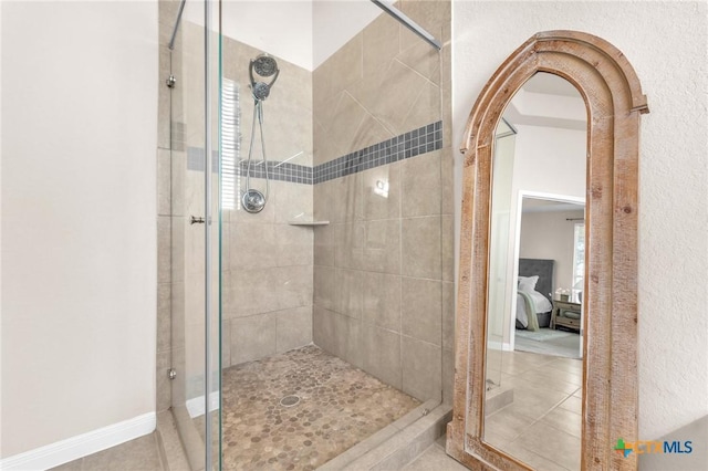 bathroom with an enclosed shower and tile patterned flooring