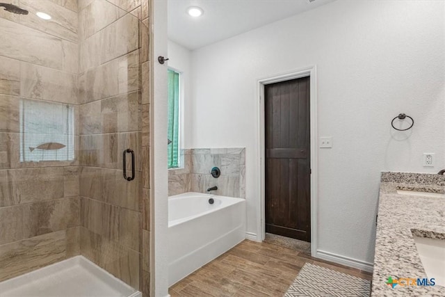 8409 Glade Dr, Temple, TX 76502 - full bathroom with a garden tub, wood finished floors, a stall shower, and double vanity