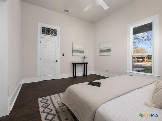 bedroom featuring ceiling fan, visible vents, baseboards, and wood finished floors