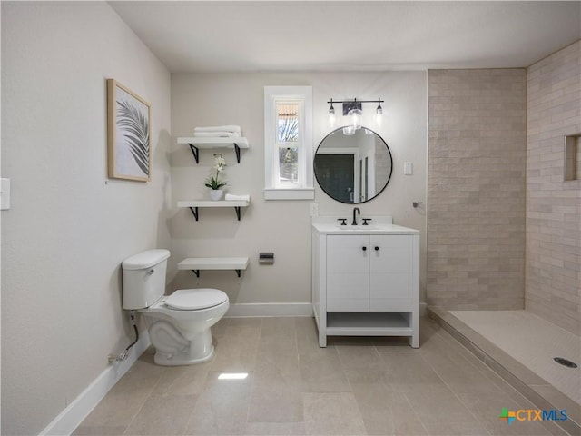 bathroom featuring toilet, baseboards, tile patterned flooring, tiled shower, and vanity