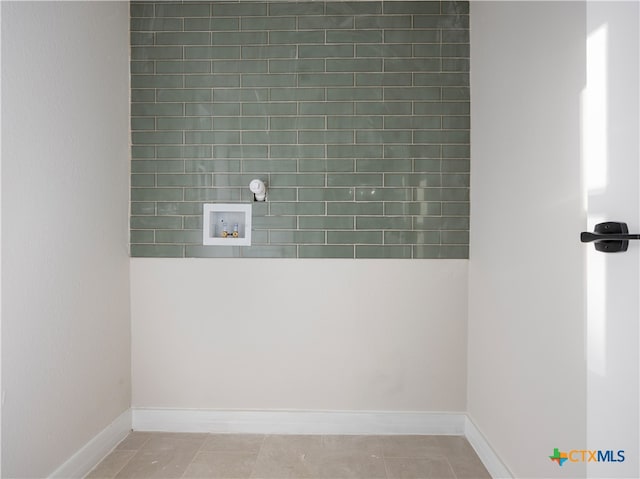 clothes washing area featuring laundry area, hookup for a washing machine, light tile patterned floors, and baseboards