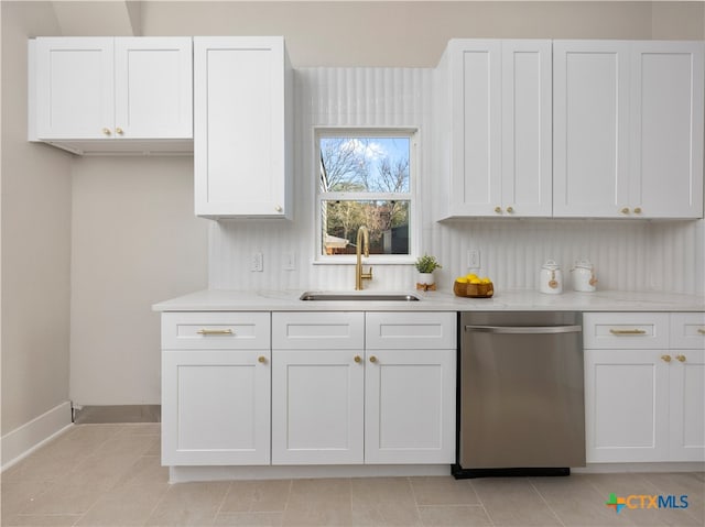 kitchen with baseboards, light tile patterned flooring, a sink, white cabinets, and dishwasher