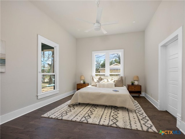 bedroom with multiple windows, baseboards, and dark wood-style flooring