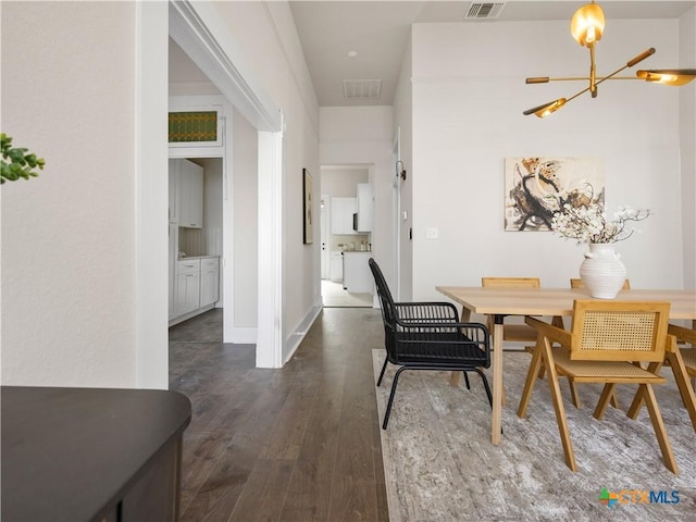 dining area with visible vents, baseboards, a notable chandelier, and dark wood-style floors