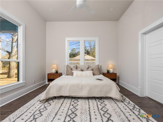 bedroom with a ceiling fan, multiple windows, baseboards, and dark wood-style flooring