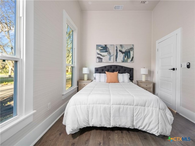 bedroom featuring visible vents, baseboards, and wood finished floors