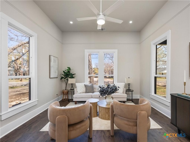 living area featuring a ceiling fan, baseboards, visible vents, and dark wood-style flooring