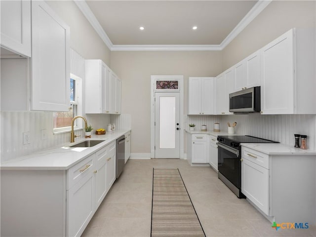 kitchen with ornamental molding, a sink, tasteful backsplash, white cabinetry, and stainless steel appliances