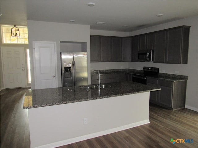 10018 Kensley Rose Dr, Killeen, TX 76542 - kitchen with appliances with stainless steel finishes, dark stone countertops, dark wood finished floors, and a center island with sink