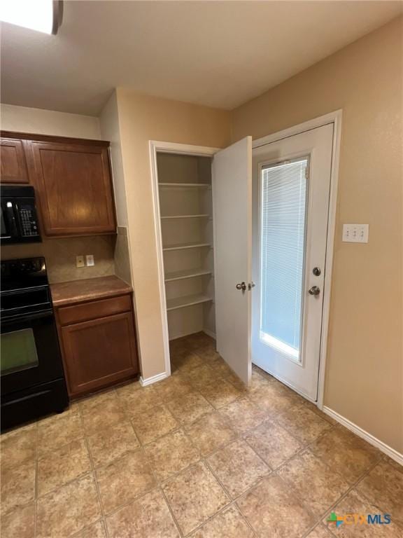 9109 Bellgrove Ct, Killeen, TX 76542 - kitchen with black microwave, baseboards, and range