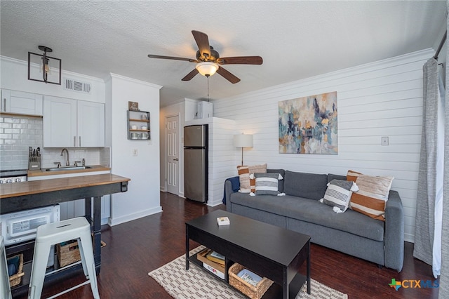3938 Surfside Blvd Unit 3116, Corpus Christi, TX 78402 - living room with a ceiling fan, dark wood-style flooring, crown molding, a textured ceiling, and baseboards