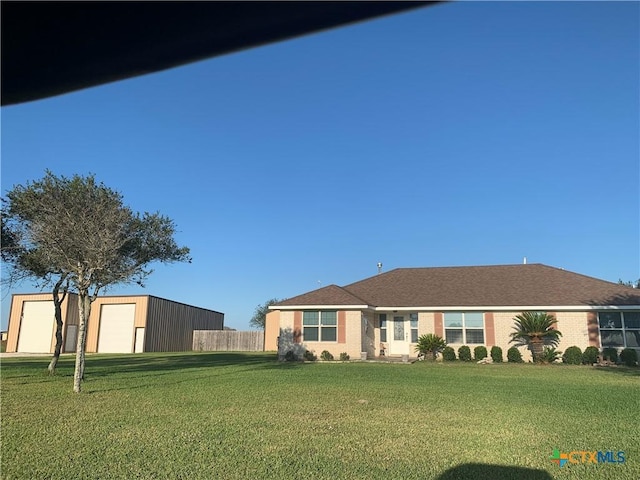 ranch-style home featuring a garage and a front lawn