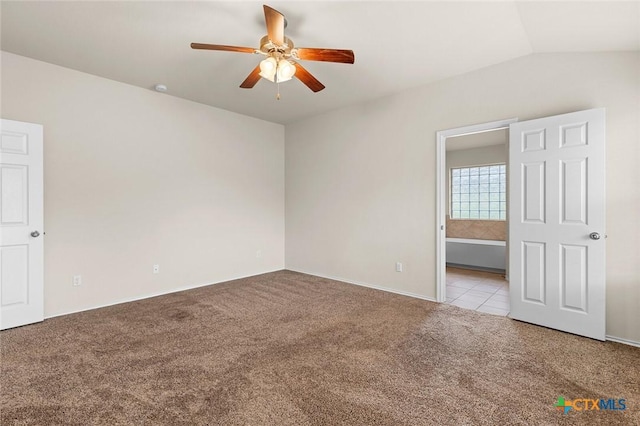 carpeted empty room with vaulted ceiling and ceiling fan