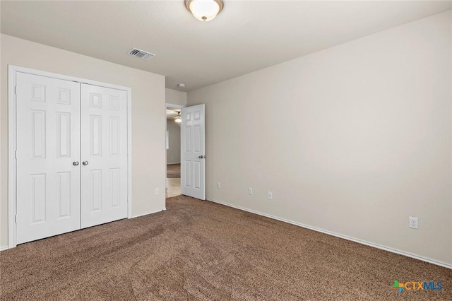 unfurnished bedroom featuring carpet flooring and a closet