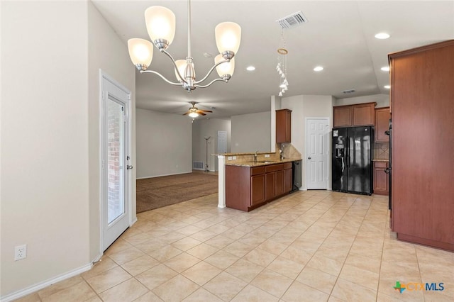 kitchen featuring tasteful backsplash, sink, hanging light fixtures, light stone counters, and black appliances