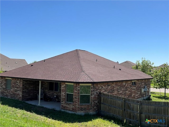 back of property featuring a patio and a lawn