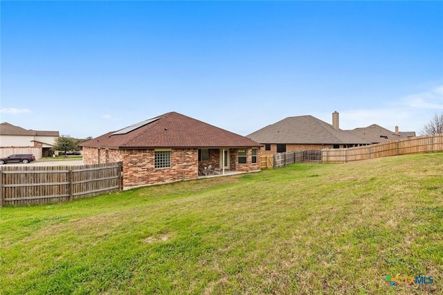 rear view of property featuring a lawn