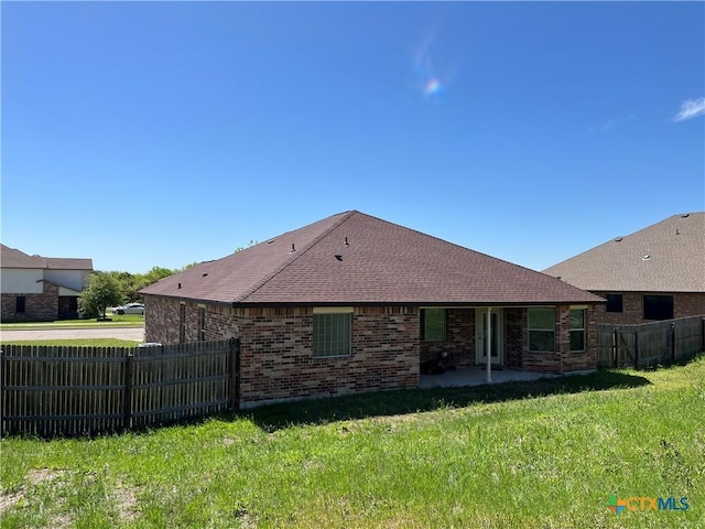 rear view of property with a yard and a patio