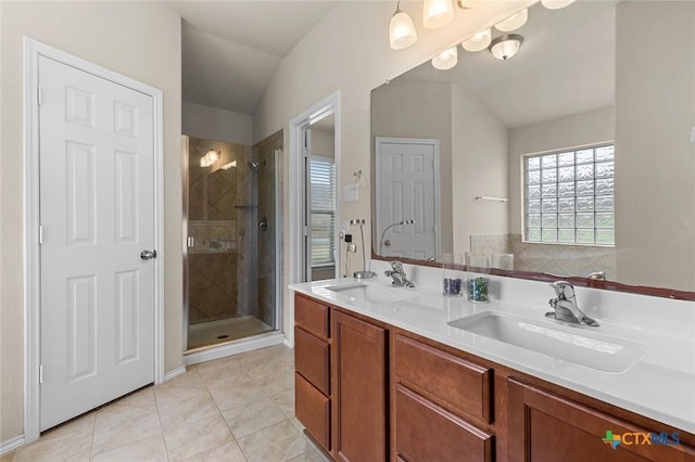 bathroom featuring lofted ceiling, vanity, a shower with shower door, and tile patterned floors