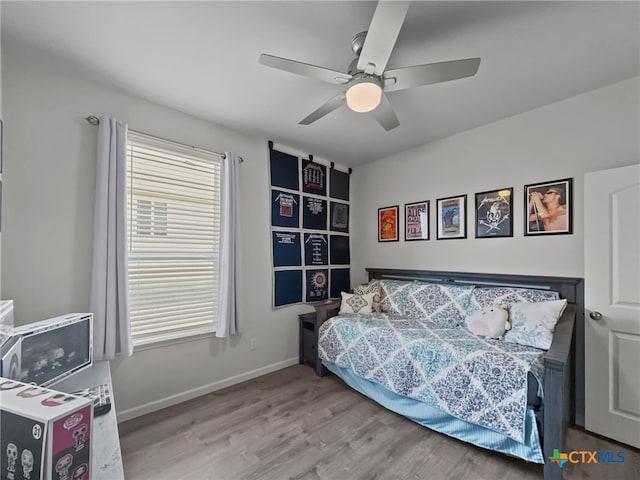 bedroom with wood finished floors, a ceiling fan, and baseboards