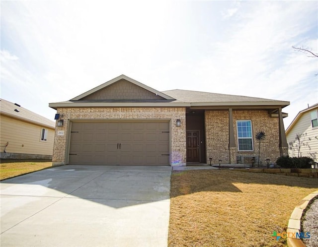 single story home featuring a garage, concrete driveway, brick siding, and a front lawn