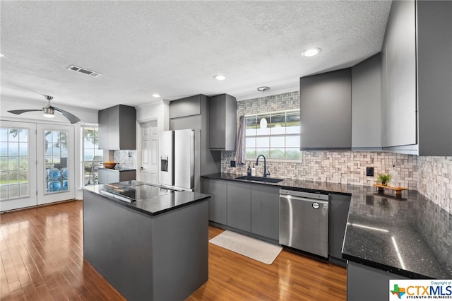 kitchen featuring a textured ceiling, stainless steel appliances, dark hardwood / wood-style floors, and sink