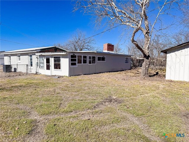 rear view of property with a lawn