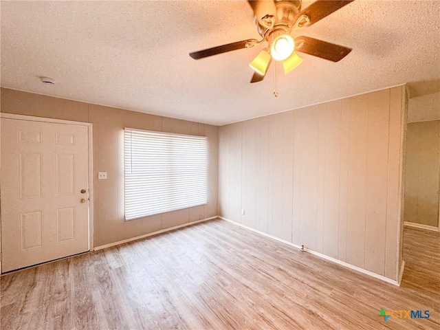 foyer entrance featuring ceiling fan, a textured ceiling, and light hardwood / wood-style flooring