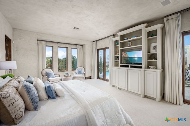 bedroom featuring access to exterior, visible vents, and light colored carpet