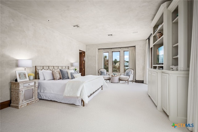 bedroom featuring light carpet, visible vents, and baseboards