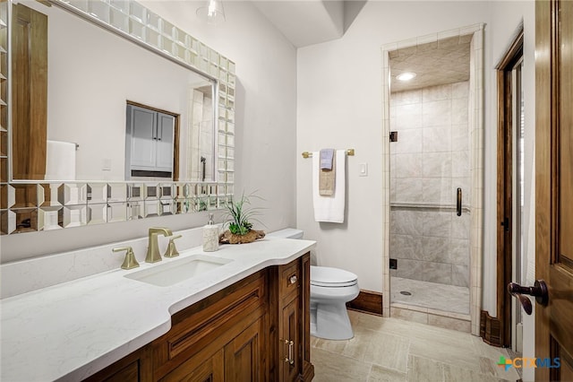 full bathroom featuring a stall shower, vanity, and toilet