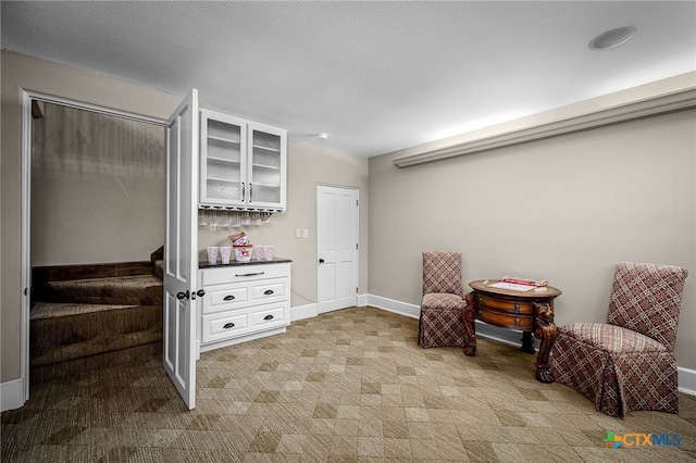 sitting room with stairs and baseboards