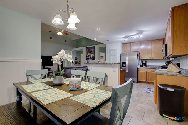 dining area featuring ceiling fan with notable chandelier