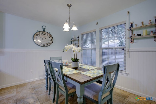 126 Breezy St, Rockport, TX 78382 - tiled dining space with a chandelier and a wainscoted wall