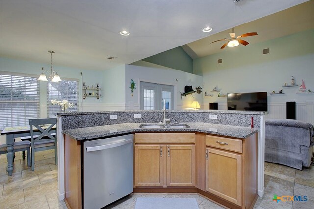 kitchen with dishwasher, sink, light stone counters, and vaulted ceiling